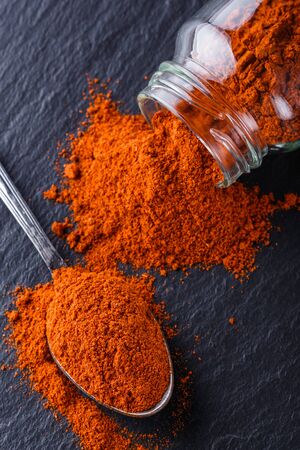 aromatic spicy chilli powder on a dark stone background.の写真素材