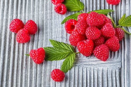 juicy fresh natural raspberries on a gray wooden rustic background.