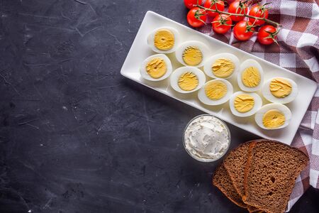 boiled chicken eggs on a dark stone background.