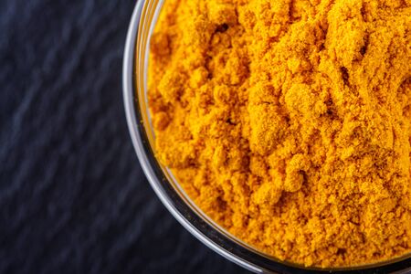 natural turmeric powder on a dark stone background.の写真素材