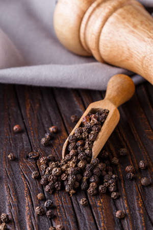 aromatic black pepper on a dark wooden rustic background.の写真素材