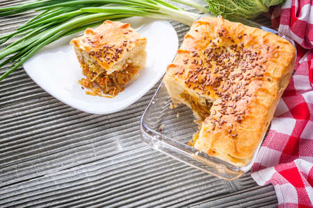 freshly baked cabbage pie on rustic wooden background.の写真素材