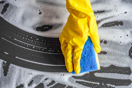 young woman housewife washes a dirty stone table.