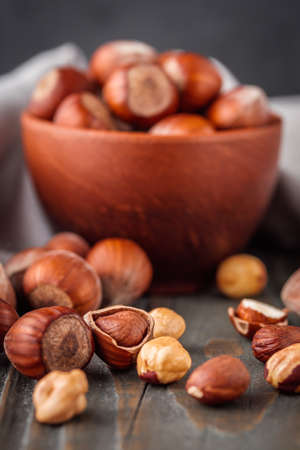 fresh natural hazelnuts on a dark wooden rustic background.