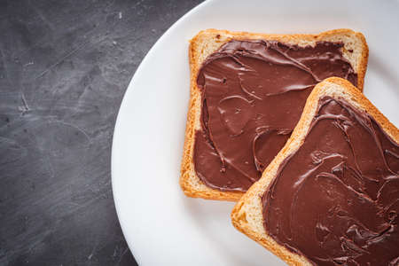 toasts with chocolate butter on a dark stone background.