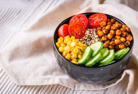 bowl of healthy quinoa with vegetables on a white rustic wooden background.の写真素材