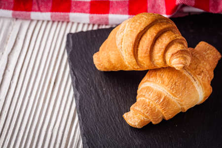 delicious fresh croissant on a white wooden rustic background.の写真素材