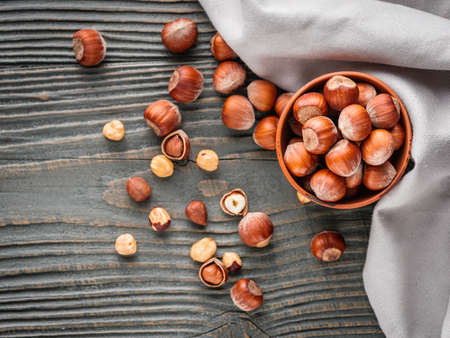 fresh natural hazelnuts on a dark wooden rustic background.