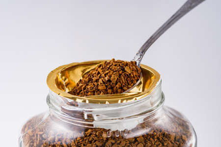 instant coffee granules on a white acrylic background.