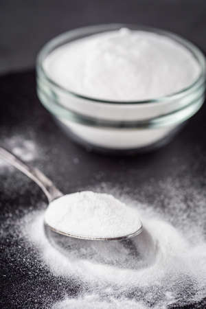 baking soda powder on a dark stone background.
