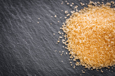 cane brown sugar on a dark stone background.の写真素材
