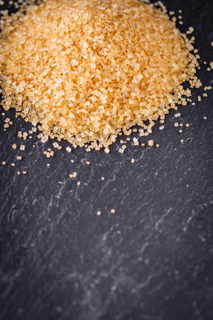 cane brown sugar on a dark stone background.の写真素材