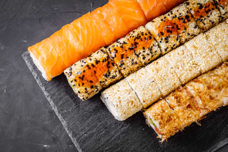 appetizing set of sushi roll on a black stone plate.の写真素材