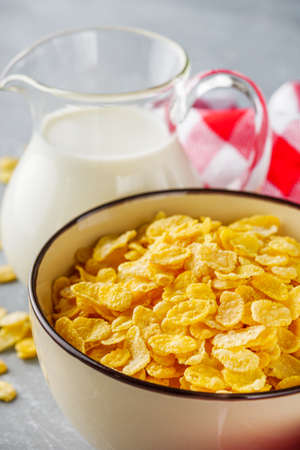 crispy golden cornflakes on a gray concrete background.