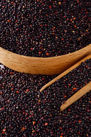 black quinoa seeds on a white acrylic background.