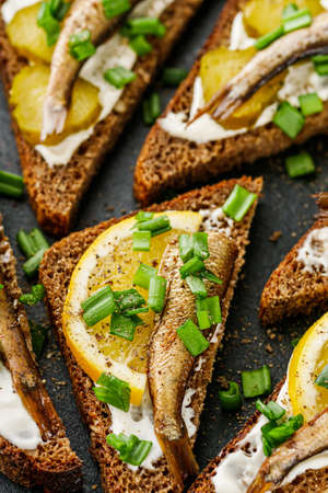 canapes with sprats on a black stone tray.の写真素材