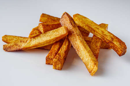 golden french fries on a white acrylic background.