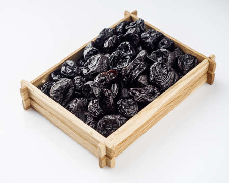 delicious dried prunes on a white acrylic background.の写真素材