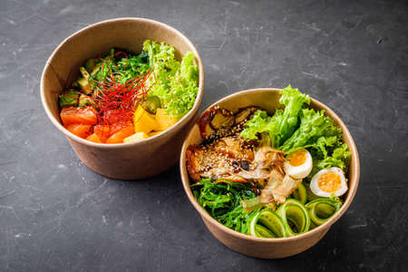 delicious poke bowl with fresh vegetables and seafood on a black background.