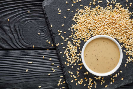 sesame tahini paste on a black stone background.の写真素材