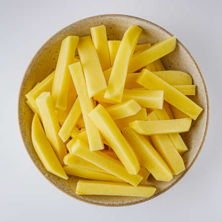 peeled potatoes on a white acrylic background.