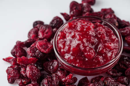 dried cranberry on a white acrylic background.