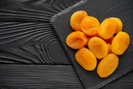 delicious dried apricots on a black wooden rustic background.の写真素材