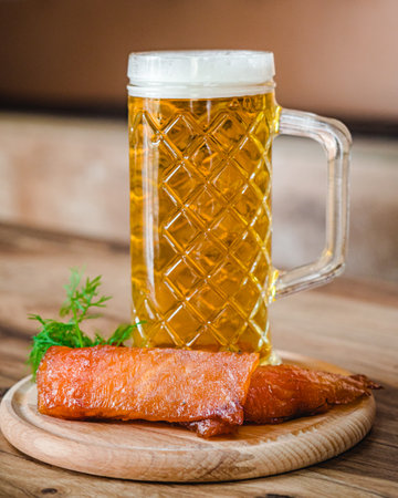 mug of beer and a set of dry fish snacks on a dark rustic wooden background.の写真素材