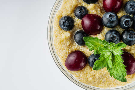sweet porridge with quinoa and berries on a white background.