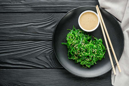 fresh delicious Chukka Wakame salad on a black wooden rustic background.