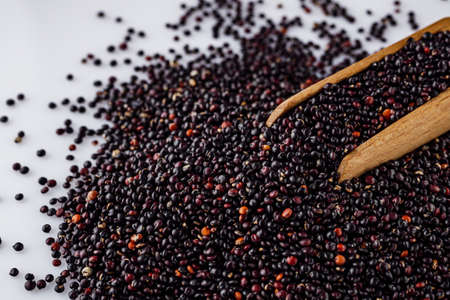 black quinoa seeds on a white acrylic background.