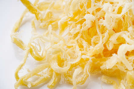 dried squid meat on a white acrylic background.