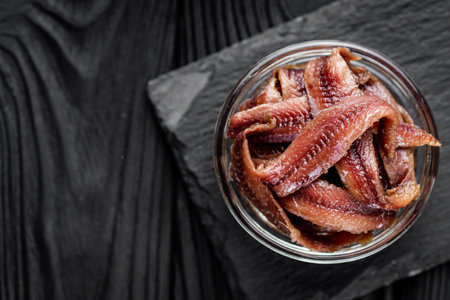 canned anchovy fillet on a black wooden rustic background.の写真素材