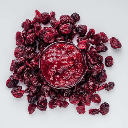 dried cranberry on a white acrylic background.