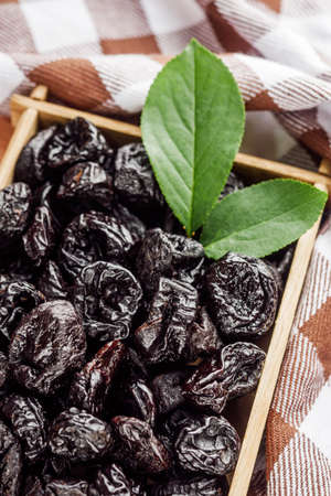delicious dried prunes on a wooden rustic background.の写真素材