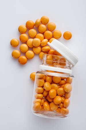 orange valerian pills on a white acrylic background.