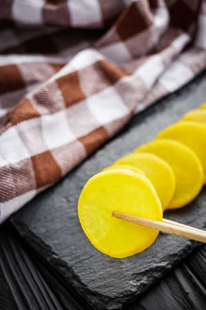 takuan traditional Japanese marinated daikon radish on a dark black rustic wooden background.の写真素材