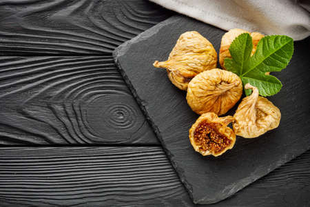 delicious dried figs on a black rustic wooden background.の写真素材