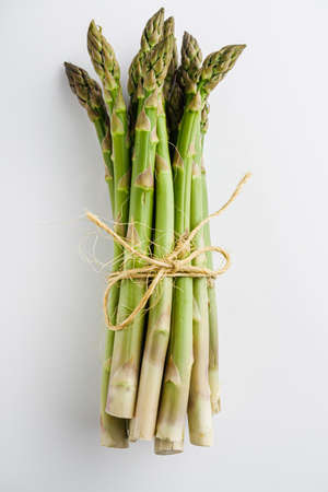 raw green asparagus on a white acrylic background.の写真素材