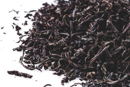 dried black tea on a white acrylic background.
