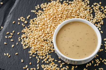sesame tahini paste on a black stone background.