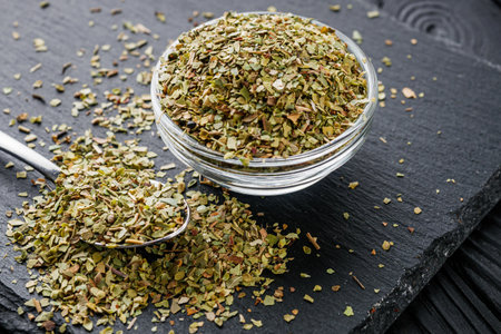 fragrant dried oregano marjoram on a black stone background.の写真素材