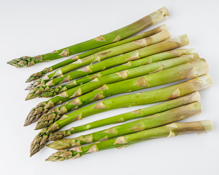 raw green asparagus on a white acrylic background.の写真素材