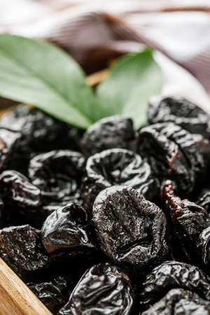 delicious dried prunes on a wooden rustic background.の写真素材