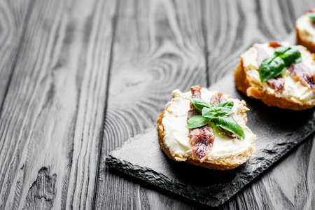 sandwich with anchovy fillet on a tray for serving on a black wooden rustic background.の写真素材