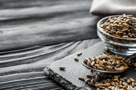 milk thistle seeds on a black wooden rustic background.の写真素材