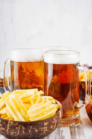 mug of beer and a set of dry fish snacks on a white wooden rustic background.の写真素材
