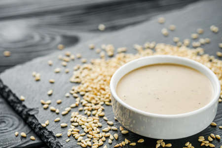 sesame tahini paste on a black stone background.の写真素材