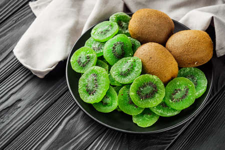 green dried kiwi on a black wooden rustic background.の写真素材