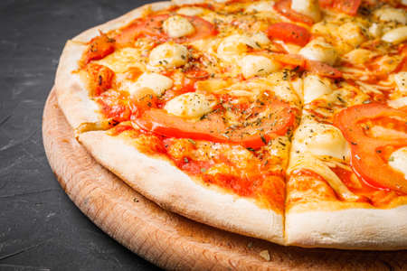 hot delicious traditional italian pizza on a dark stone background.の写真素材
